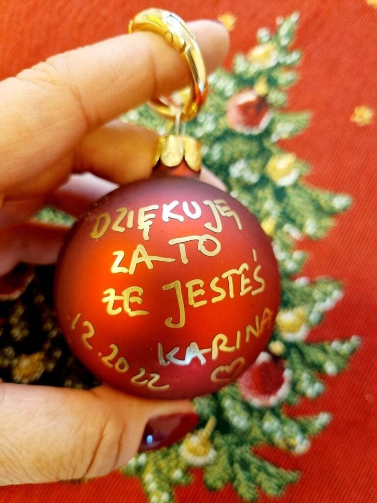 Czerwona bombka z napisem "Dziękuje za to że jesteś"