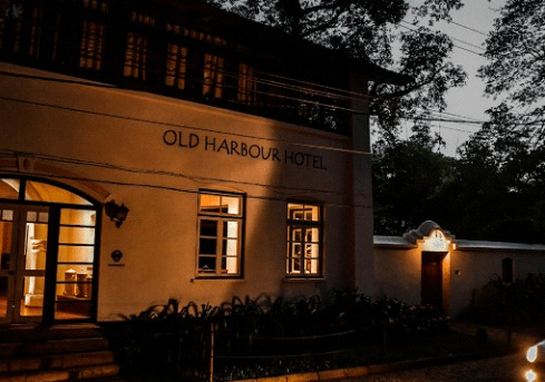 Noc, stary budynek z napisem "OLD HARBOUR" lekko oświetlony.